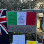 Family in the woods, sit-in outside foster home: signs and toys for the children